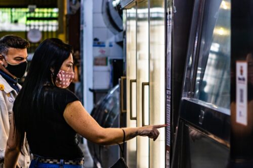 woman in black t-shirt standing beside glass window